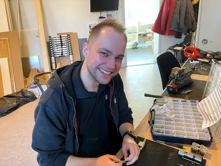 Låsesmed arbejder med cylinder i HV Låsetekniks værksted